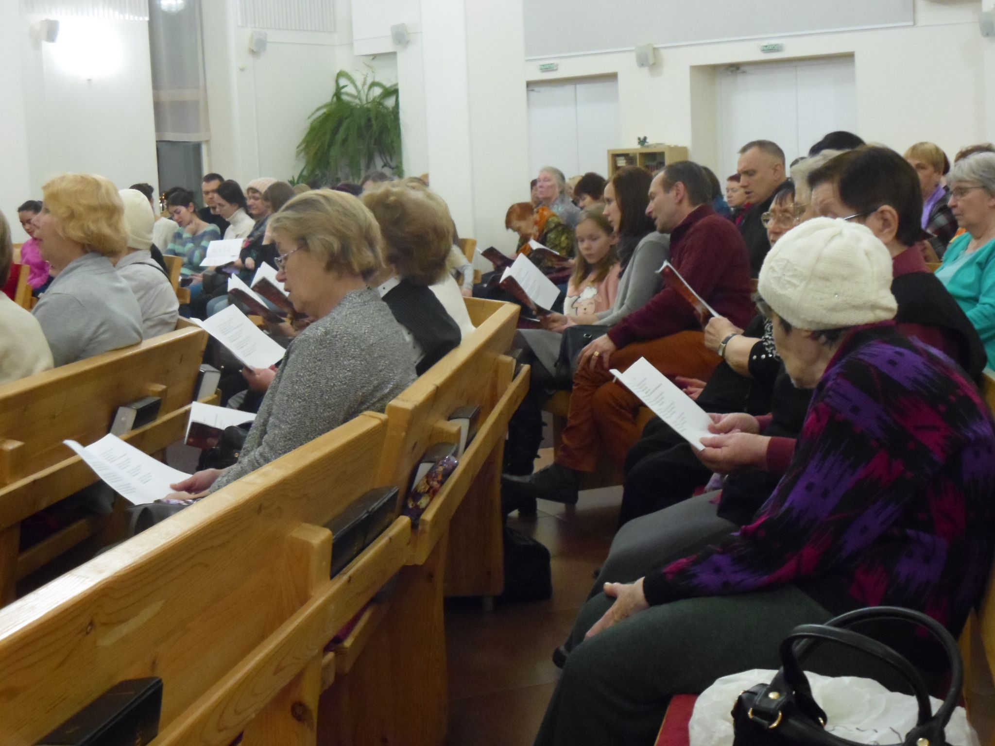 Petroskoin evankelis-luterilaisen kirkon seurakuntalaiset ovat laulamassa jouluhymnejä. Joukossa on myös nuoria ja lapsia. Kuva: Marina Tolstyh