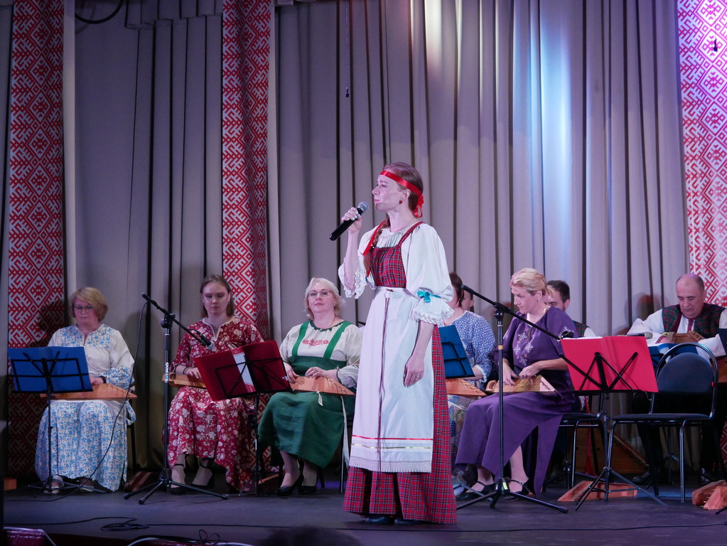Anna Andrianova laulo karjalakši ta venäjäkši kantelehella šoittajien yhtyvehen šoitolla. Kuva: Uljana Tikkanen